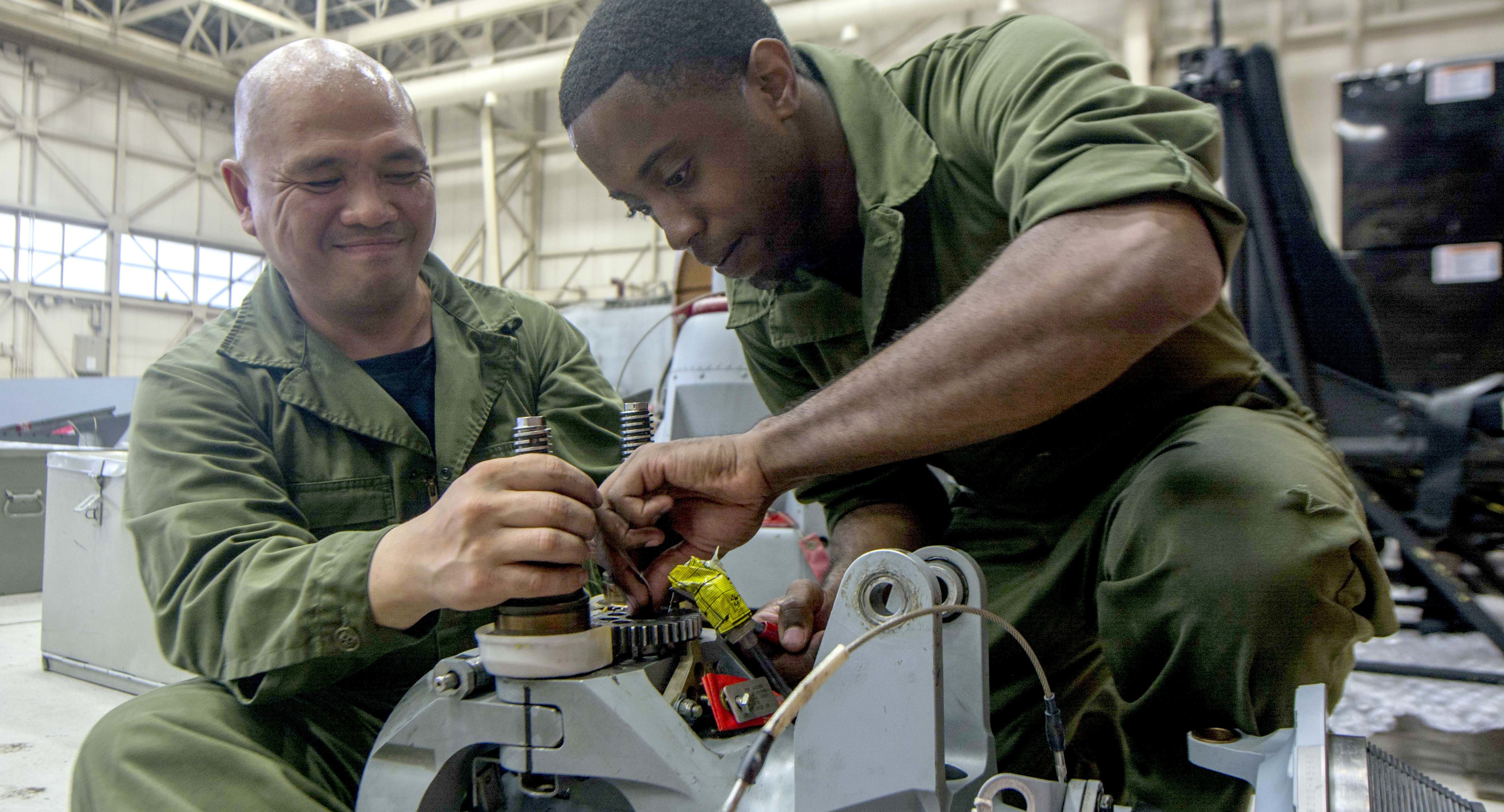 Navy mechanics work on a MH-60R Seahawk helicopter