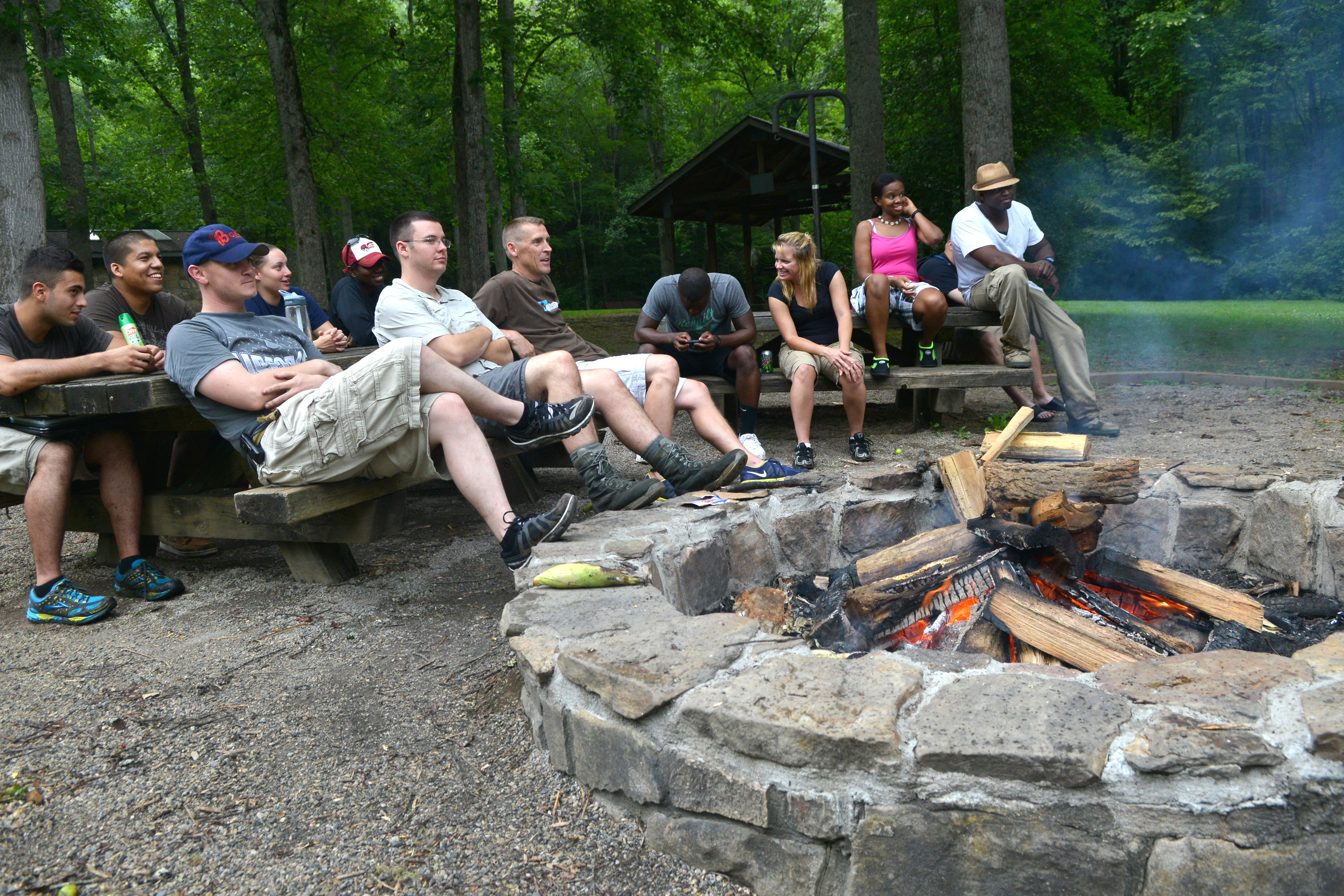 A group of airmen gather around a campfire sharing life stories.