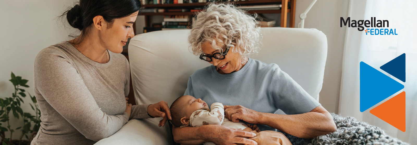 Grandmother holding baby grandchild as her daughter kneels caressing the baby's face.