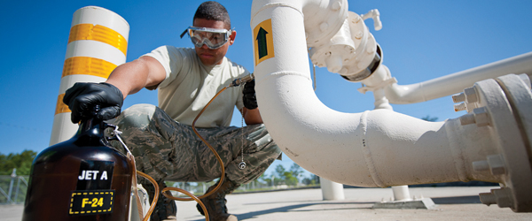 A military member examines a sample of Jet A Jet fuel