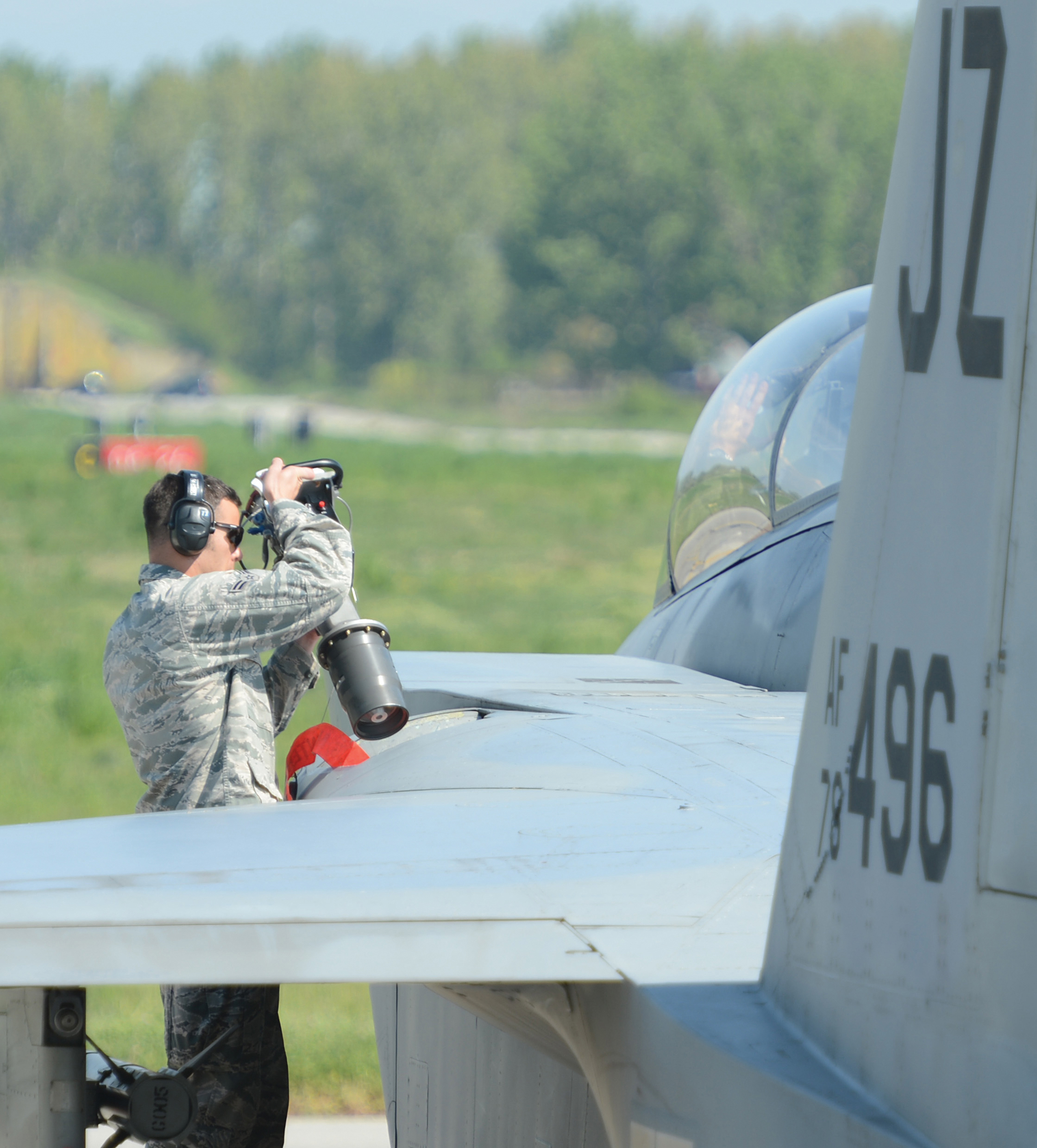 A military member refuels an airplane