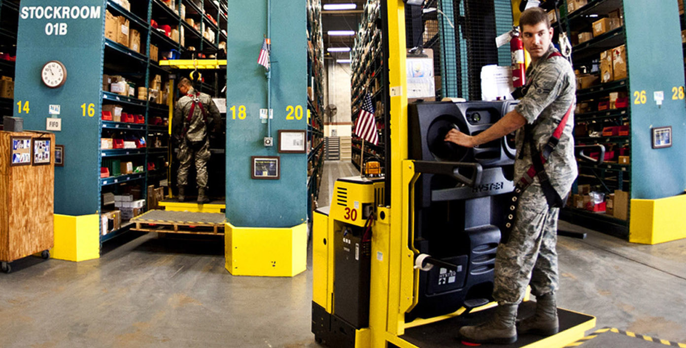 Image of a forklift driver pulling out of an aisle of a stockroom