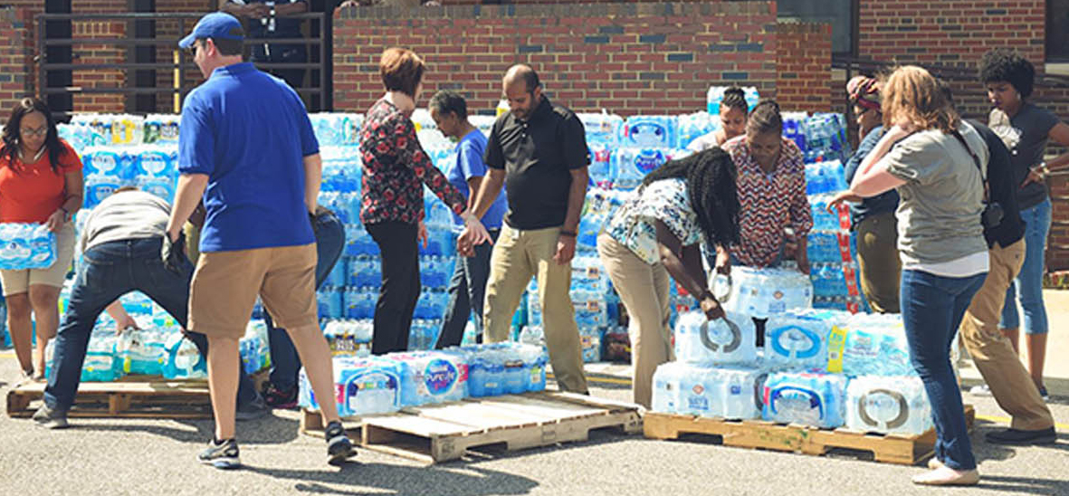 Image of a group of employees helping distribute cases of water onto pallets