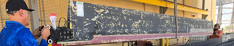 Two workers move a large aircraft part