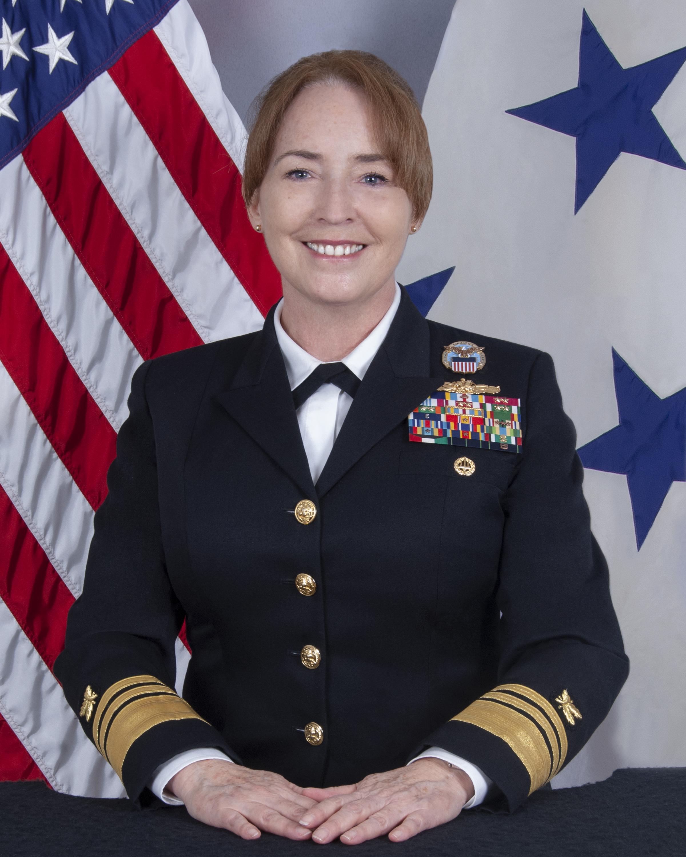 Portrait of Vice Admiral Michelle C. Skubic in front of U.S. and Navy three-star flags
